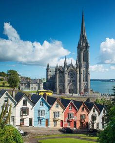 an image of a city with colorful houses in the foreground and a church on the other side