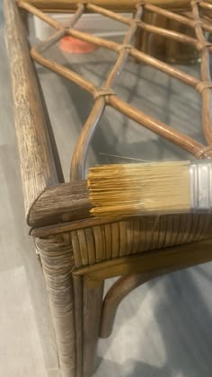 a paintbrush sitting on top of a wicker chair with wood slats around it