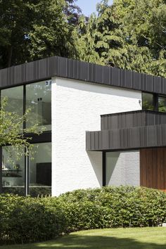 a white brick house surrounded by trees and bushes