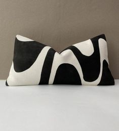 a black and white pillow sitting on top of a bed