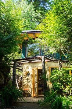 a small house surrounded by trees and greenery