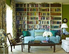 a living room filled with furniture and bookshelves covered in lots of bookcases