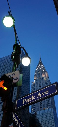 street signs and traffic lights in front of skyscrapers at dusk, new york city