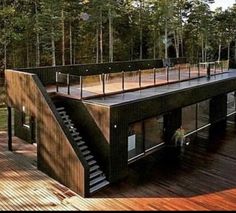 an aerial view of a house in the woods with stairs leading up to it's roof