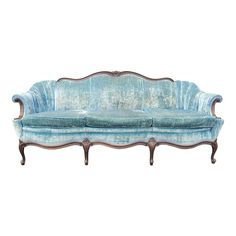 an old fashioned couch with blue velvet upholstered on the back and arms, against a white background