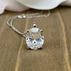 "The pendant pictured is a simulated diamond #6760 -Approximate total carat weight: approx. 3.00ctw diamond equivalent -Center Stone Size: 10x8mm - approx. 3.00ct diamond equivalent -Center Stone Shape: oval -Gem Type: simulated diamond -Stone Clarity: VVS1 -Stone Color: D -Moh's Scale: 8.5 hardness -Metal Type and Purity: 14k white gold -Setting: 4 prong basket head -Chain: 18\" delicate 14k gold chain / heavier option with lobster claw available (use dropdown to select) -Country of Manufacturi Formal Oval Necklace With Prong Setting, Oval Cubic Zirconia Necklaces For Formal Occasions, Classic Oval Link Gemstone Jewelry, Anniversary Oval Link Necklace With Diamond Accents, Dazzling Diamond Oval Pendant Jewelry, Oval Diamond Cut Necklace For Anniversary, Diamond White Jewelry With Diamond Accents, Oval Pendant, Dazzling Oval Necklace With Brilliant Cut, Oval Moissanite Necklaces