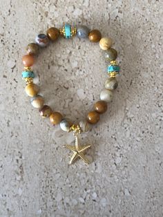 Starfish Bracelet featuring 8MM smooth round bamboo agate stones accented with 8MM turquoise roundelle beads and gold plated spacer with a 22MM gold filled starfish charm. GIFT BOXED Gemstone Stretch Bracelets, Resort Jewelry, Starfish Jewelry, Bamboo Leaf, Dangle Bracelet, Beachy Jewelry, Starfish Bracelet, Diffuser Bracelets, Handcrafted Artisan Jewelry