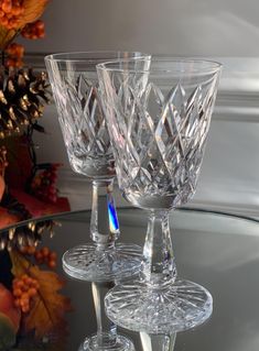 three wine glasses sitting on top of a glass table