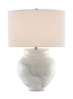 a white table lamp with a beige shade on the base and a light in front of it