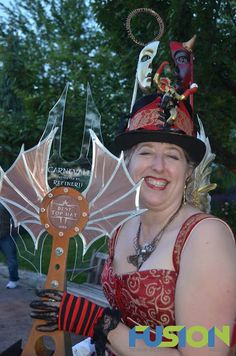 a woman wearing a costume and holding an award in front of her face, smiling at the camera