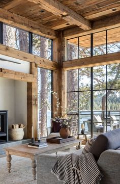 a living room filled with lots of furniture next to a fire place and large windows