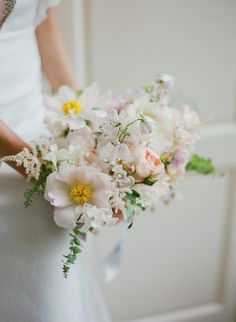 a bride holding a bouquet of flowers in her hand