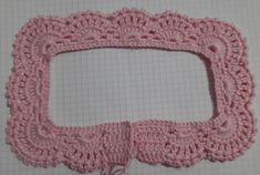 a pink crocheted frame sitting on top of a table