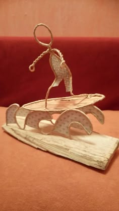 a sculpture of a person riding a surfboard on top of a wooden board with the word love