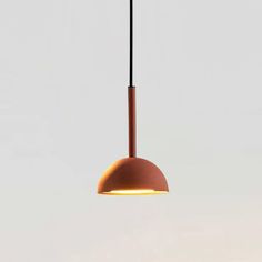 an orange light hanging from a ceiling in a room with white walls and flooring