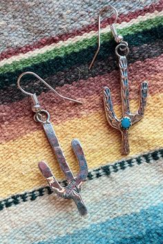 Sterling Silver and Turquoise Saguaro Cactus Earrings Native American Made Genuine Turquoise stones. Stone color and matrix may vary due to their natural characteristics. Cactus stamped sterling. Ear wires are silver plated. Cactus measures 1 1/4" long not including the french hook. 3 mm stones Western Style Turquoise Dangle Jewelry, Nickel-free Turquoise Western Jewelry, Western Style Nickel Free Turquoise Jewelry, Western Style Dangle Earrings For Pierced Ears, Southwestern Turquoise Metal Jewelry, Southwestern Nickel-free Jewelry As Gift, Nickel-free Southwestern Style Jewelry As Gift, Nickel Free Southwestern Jewelry For Gift, Nickel-free Southwestern Style Jewelry For Gift