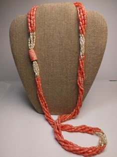 This mid-century multi-strand necklace is a beautiful combination of natural coral and Kashi (river) pearls. The five-strand necklace contrasts the pink coral with luminescent river pearls and 14k yellow gold beads. The long 32-inch length easily slips on for a seamless design. A large, carved coral bead with an Asian motif is the finishing touch of this special necklace. * 32-inch length * 5 strands * Coral and Kashi (river) pearl beads * 14k gold accent beads Thank you for visiting Second Chap Orange Multi-strand Hand-strung Jewelry, Orange Hand-strung Multi-strand Jewelry, Elegant Double Strand Coral Necklace, Multi-strand Red Coral Beaded Necklaces, Multi-strand Coral Beaded Necklace As Gift, Multi-strand Coral Beaded Necklace For Gift, Coral Multi-strand Beaded Necklaces, Coral Multi-strand Beaded Necklace, Coral Multi-strand Beaded Necklace For Gift