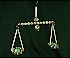 a pair of earrings is hanging on a black background with beads and glass bead details