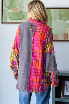 a woman standing in front of a painting and wearing a colorful jacket with ruffles