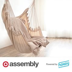 a hammock hanging from the ceiling in a room with hardwood floors and white walls