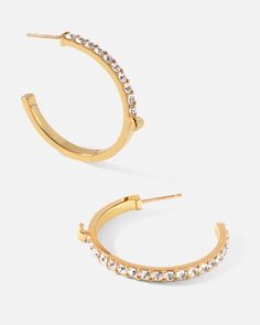 Slim lines and glittering stones give these hoop earrings a surprising dose of effortless glamor and contemporary luxury, fashioned into a subversive-basic design. Keep it casual and cool with a pair of classic hoops upgraded for your modern lifestyle.
 
Size: 3×33mm
Stone Color: Shiny White
Material: Crystals, 18k Gold Plated On Brass Sparkling Stones Hoop Earrings, Modern Hoop Earrings With Plating For Anniversary, Everyday Hoop Earrings With Sparkling Stones, Modern Hoop Earrings With Sparkling Stones, Elegant Hoop Earrings With Sparkling Stones For Everyday, Elegant Everyday Hoop Earrings With Sparkling Stones, Everyday Elegant Hoop Earrings With Sparkling Stones, Everyday Gold Hoop Earrings With Sparkling Stones, Earrings With Crystals