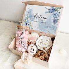 an open box with personal items inside on a white tableclothed surface next to flowers