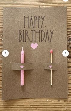 a birthday card with two candles and hearts on the top one is made out of brown paper