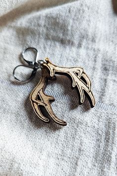 a metal keychain with an animal's head on it sitting on top of a white cloth