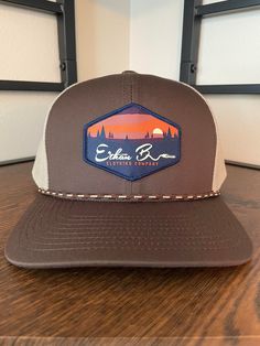 Ethan b. Clothing Co. Sunset hat. Hat color Brown/Khaki Pro-stitched finish CROWN: Mid-Profile, Pro-Model VISOR: Curved CLOSURE: Snapback FABRIC: Cotton Blend, Trucker Mesh Brown Flat Bill Hat For Camping, Brown Six-panel Outdoor Hats, Brown Six-panel Hat For Outdoor Activities, Brown Flat Bill Baseball Cap For Outdoor, Brown Flat Bill Snapback Hat For Camping, Brown Outdoor Baseball Cap, Brown Baseball Cap For Camping, Brown Six-panel Snapback Hat For Outdoor, Brown Snapback Hat For Outdoor Activities