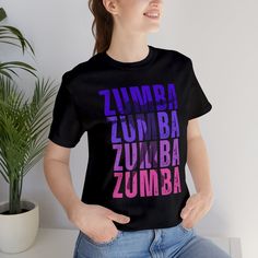 a woman wearing a black t - shirt with the word zumba printed on it