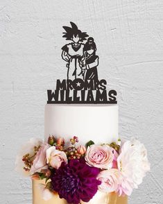 a wedding cake decorated with flowers and a cartoon character on top that says, mr & mrs williams