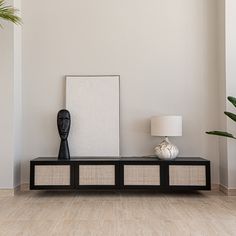 a living room with a black and white shelf next to a vase on the floor