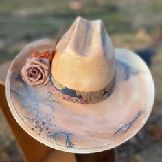 Take on the wild west in style with our Blessed Hand Painted Hat. Made from premium straw, this small-sized cowboy hat is a statement piece. Hand painted flowers and vintage details, accented with metal feathers, add a unique touch. Custom Curved Brim Straw Hat For Rodeo, Rustic Curved Brim Straw Hat For Kentucky Derby, Western Felt Hat With Short Brim For Summer, Artisan Felt Hat For Summer Rodeo, Western Style Felt Hat With Short Brim For Summer, Custom Flat Brim Straw Hat For Rodeo, Western Style Felt Hat For Summer Rodeo, Rustic Hat For Kentucky Derby And Country Events, Western Style Hats For Spring