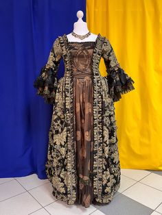 The dress is black jacuard with a darck green taffeta. The main decorative piece of the dress are the large ruffles, patterned on the edges of the top and the center bottom of the skirt. The closure in the back is black lacing with grommets. The sleeves are trimmed with openwork lace. In order to be able to fix the skirts in a desired position, the dress comes with soft crinoline. The suit consists of: a dress. Material: jacquard, taffeta. We have this dress available only in size L(14). The dre Elegant Black Gown For Fancy Dress, Elegant Fitted Vintage Dress For Fancy Dress, Victorian Style Ball Gown For Costume Party, Victorian Ball Gown For Costume Party, Historical Design Ball Gown For Evening, Elegant Fitted Costume Dress, Black Ball Gown For Fancy Dress, Victorian Dress For Costume Party, Elegant Costume Dresses With Ruffles