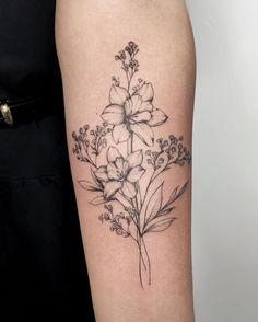 a black and white flower tattoo on the right arm, with flowers growing out of it