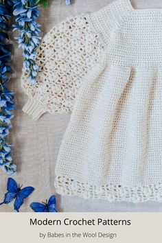 two crocheted sweaters next to blue flowers on a white surface with text that reads modern crochet patterns by babes in the wool design