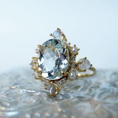 Read about our payment plans before proceeding."Do you want to build a snowman?"- FrozenThe "Aquamarine Elsa Moonstone Pearl Diamond ring" features an approximately 2.54ct oval large natural Aquamarine. Framed with glowy cabochon moonstones, freshwater pearls, and natural white diamonds. Handcrafted in 14k yellow gold, rose gold, and white gold. All orders come in our Tippy Taste ring box. This ring is handmade and designed in NYC. 14K solid gold 10*8mm natural oval Aquamarine. Approx. 2.54ct Fo Unique Multi-stone Topaz Ring For Wedding, Luxury Moonstone Ring With Accent Stones, Luxury Oval Moonstone Wedding Ring, Unique Moonstone Ring With Rose Cut Diamonds For Wedding, Unique Topaz Ring With Gemstone Accents For Wedding, Unique Topaz Wedding Ring With Gemstone Accents, Aquamarine And Pearl Ring, Luxury Moonstone Ring With Gemstone Accents For Gift, Wedding Moonstone Ring With Gemstone Accents In 14k Gold