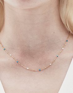 DESCRIPTION Elevate your jewellery game with the Rosa Necklace in Gold and Turquoise by Jolie & Deen. This delicate chain necklace features a stunning combination of natural turquoise stones and freshwater pearls, creating a minimalist yet eye-catching piece. Perfect for both casual and formal wear, this necklace adds a pop of subtle colour and sophistication to any outfit. Whether worn on its own for a soft statement or layered with other necklaces for a chic, trendy look, this piece is a versa Blue Delicate Chain Necklace, Turquoise Charm Necklace With Delicate Chain, Dainty Blue Necklaces With Satellite Chain, Dainty Blue Necklace With Satellite Chain, Turquoise Adjustable Chain Necklace, Adjustable Turquoise Chain Necklace, Blue Dainty Chain Necklace With Delicate Chain, Dainty Blue Chain Necklace With Delicate Chain, Blue Dainty Chain Necklace