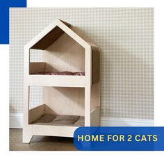 a cat house made out of wood with the words home for 2 cats below it