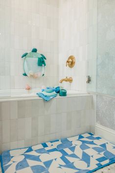 a bathroom with blue and white tiles on the floor, shower curtain, and bathtub