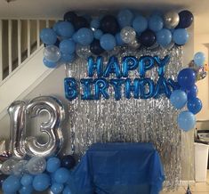 a birthday party with balloons, streamers and blue table cloths on the floor