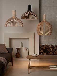 three hanging lights above a fireplace in a living room