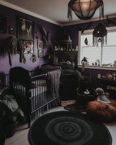 a baby's room with purple walls and pictures on the wall