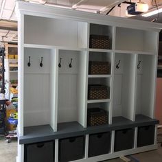 a room filled with lots of white shelves and bins next to each other in front of a wall