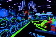 the interior of a car racing simulator with neon colors and black lights on the floor