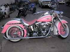 a pink and white motorcycle parked in a parking lot