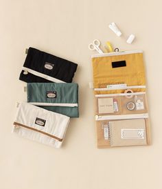 three small pouches with scissors and other items in them sitting next to each other