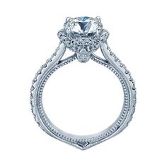 a white gold engagement ring with an oval cut diamond center surrounded by intricate filigrees