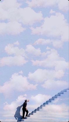 a man riding a skateboard down the side of a set of stairs under a cloudy blue sky