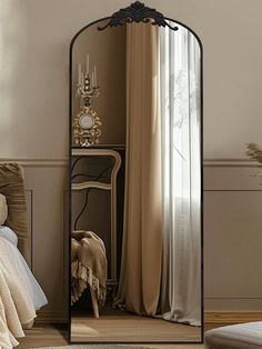 a mirror sitting on top of a wooden floor next to a bed